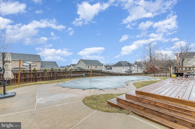 view of pool with a residential view, a fenced in pool, a fenced backyard, and a deck