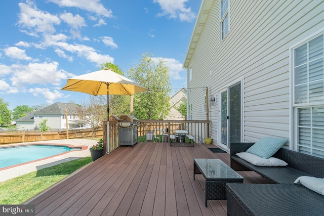 wooden terrace with area for grilling, a fenced in pool, and a fenced backyard