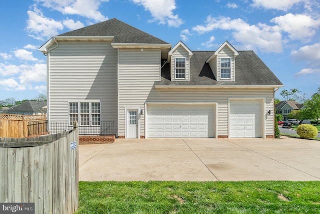 exterior space with an attached garage, a shingled roof, fence, and concrete driveway