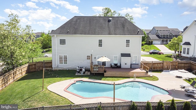 back of property with a lawn, a deck, a fenced backyard, and a patio area