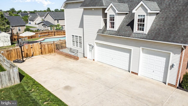 exterior space featuring roof with shingles, fence, a residential view, a gate, and driveway