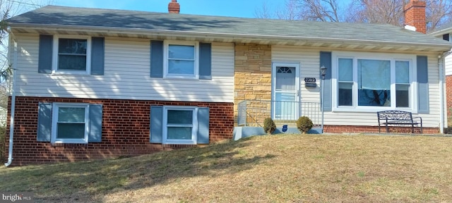 view of front of home featuring a shingled roof, a chimney, a front lawn, stone siding, and brick siding