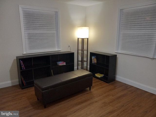 living area with baseboards and wood finished floors