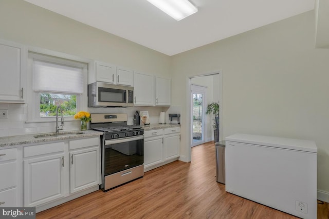 kitchen with white cabinetry, stainless steel appliances, and a sink