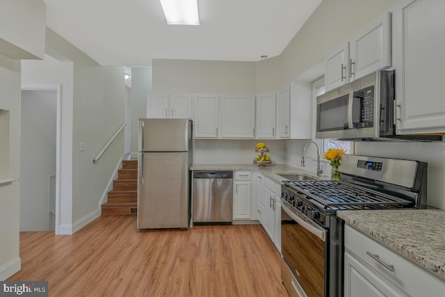 kitchen featuring a sink, light wood-type flooring, white cabinetry, and stainless steel appliances