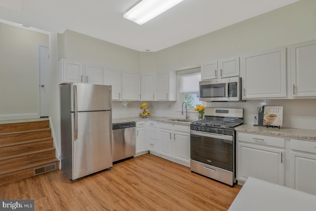 kitchen featuring white cabinets, visible vents, and stainless steel appliances