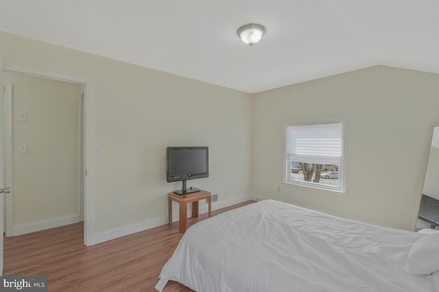 bedroom featuring baseboards and wood finished floors