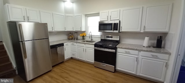 kitchen with white cabinets, appliances with stainless steel finishes, and a sink