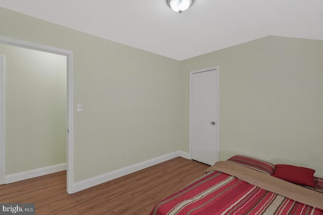 bedroom with baseboards and wood finished floors