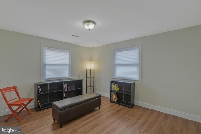 sitting room featuring plenty of natural light, wood finished floors, visible vents, and baseboards