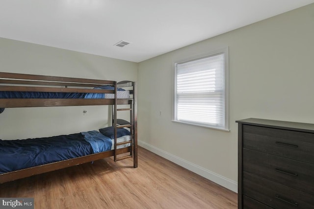 bedroom with visible vents, light wood-style flooring, and baseboards