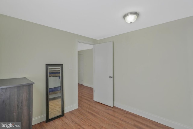 unfurnished room featuring wood finished floors and baseboards