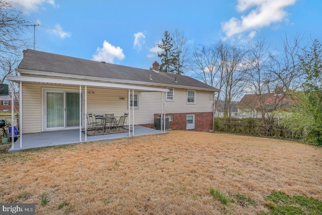 rear view of house with fence, a patio area, a lawn, and central AC