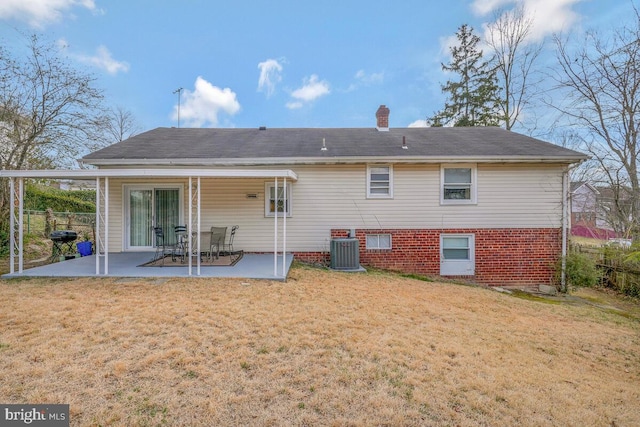 back of property with fence, central AC unit, a chimney, a yard, and a patio