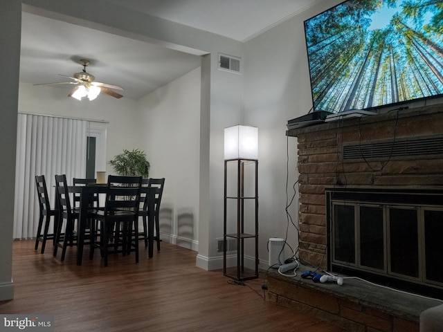 dining area with visible vents, baseboards, wood finished floors, and a fireplace