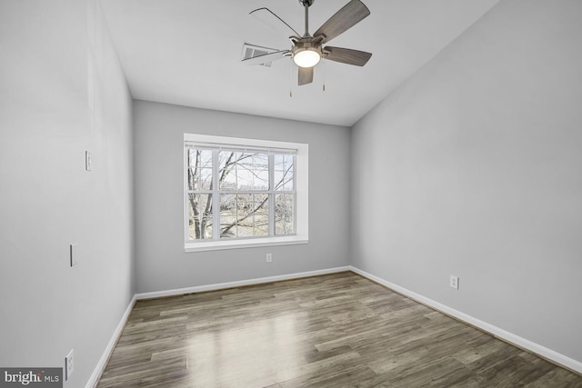 empty room featuring a ceiling fan, baseboards, and wood finished floors