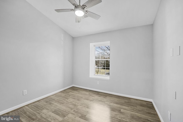 spare room with a ceiling fan, baseboards, and wood finished floors