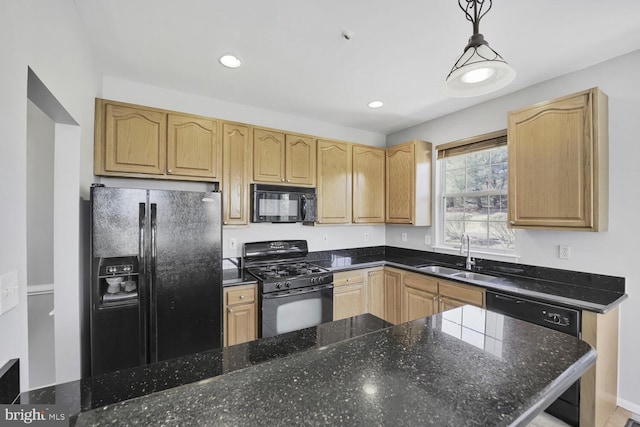 kitchen featuring recessed lighting, hanging light fixtures, a sink, dark stone counters, and black appliances