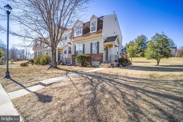 view of front of house with brick siding and a gambrel roof