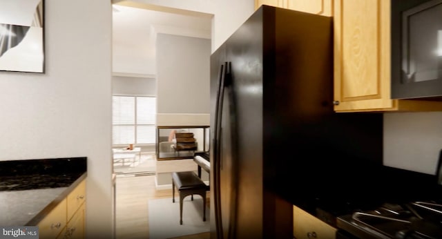 kitchen with freestanding refrigerator, wood finished floors, and light brown cabinetry