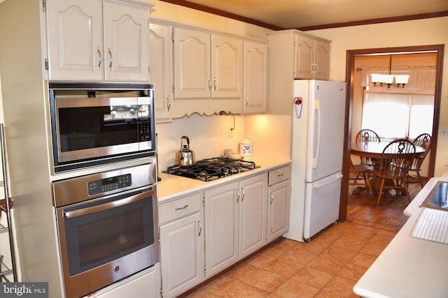 kitchen featuring crown molding, light tile patterned floors, light countertops, appliances with stainless steel finishes, and white cabinets