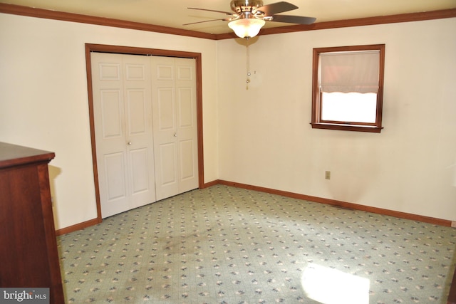 unfurnished bedroom featuring ceiling fan, baseboards, a closet, and ornamental molding