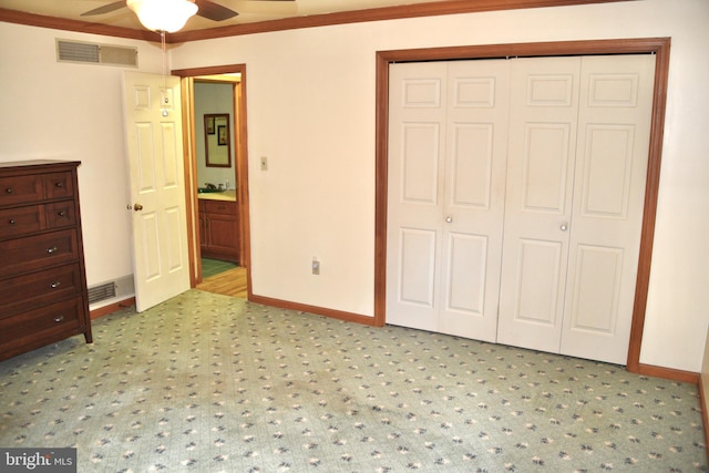 unfurnished bedroom with ornamental molding, a closet, visible vents, and baseboards