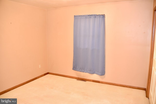 carpeted spare room featuring visible vents and baseboards