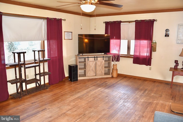 living room featuring ornamental molding, baseboards, ceiling fan, and hardwood / wood-style floors