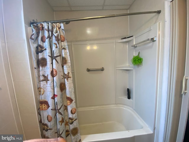 full bathroom featuring a drop ceiling and shower / tub combo with curtain