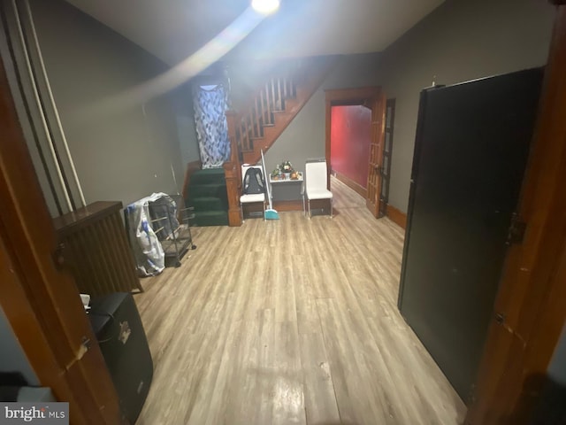 bonus room with stairs, vaulted ceiling, and wood finished floors