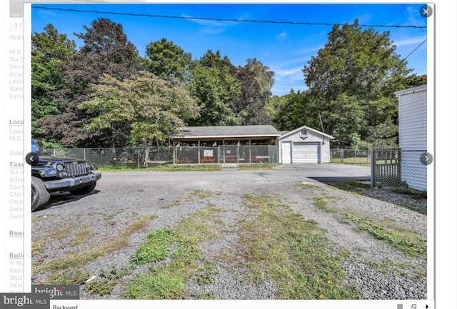 exterior space with a garage, driveway, an outdoor structure, and fence