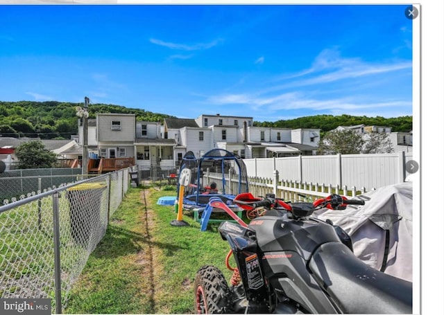 exterior space featuring a fenced backyard, a residential view, and a lawn