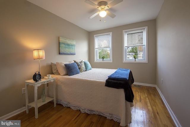 bedroom featuring baseboards, ceiling fan, visible vents, and light wood finished floors