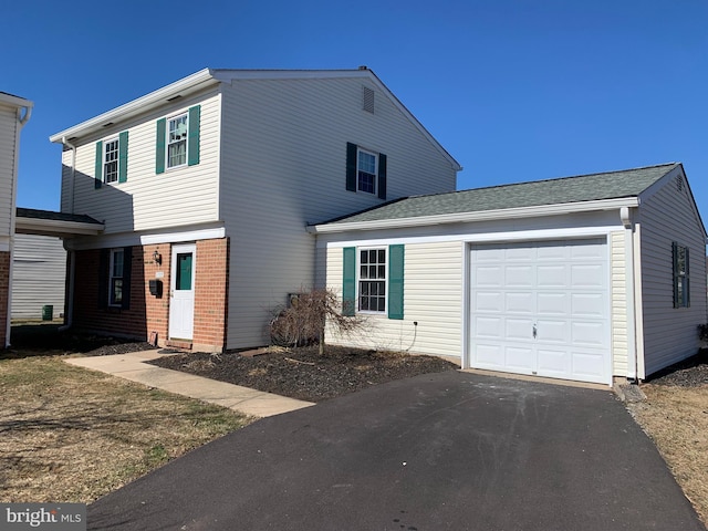 view of front of house with a garage, brick siding, and a shingled roof