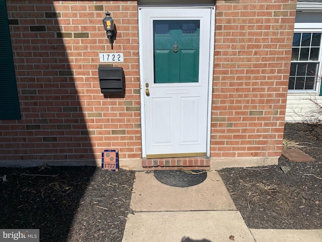 doorway to property with brick siding