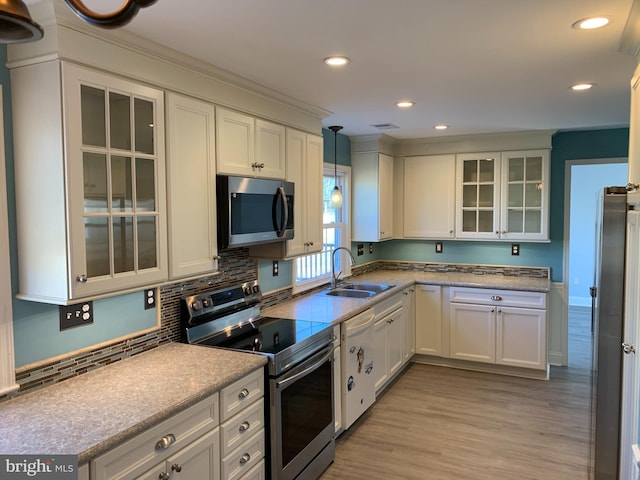 kitchen featuring appliances with stainless steel finishes, white cabinetry, and a sink