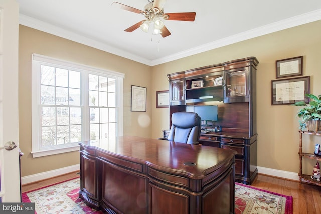 office space with baseboards, wood finished floors, ceiling fan, and ornamental molding