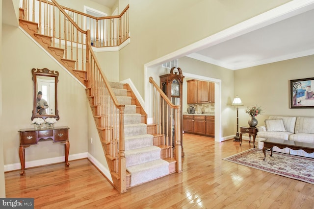 stairway with visible vents, ornamental molding, baseboards, and wood finished floors