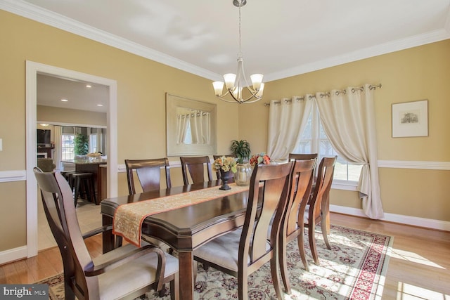 dining space with a notable chandelier, wood finished floors, baseboards, and a wealth of natural light