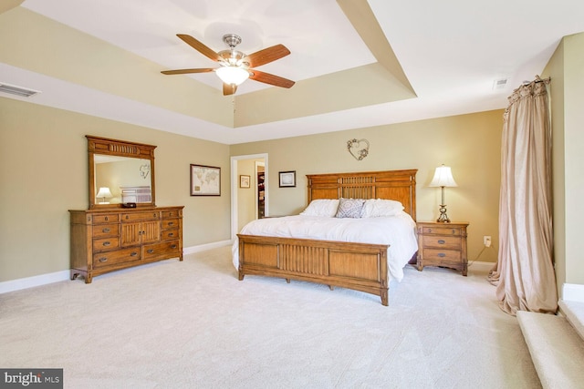 bedroom featuring visible vents, baseboards, and a tray ceiling