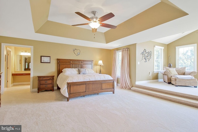 carpeted bedroom with a ceiling fan, a raised ceiling, and baseboards