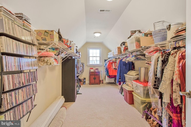 spacious closet with vaulted ceiling, visible vents, and carpet floors