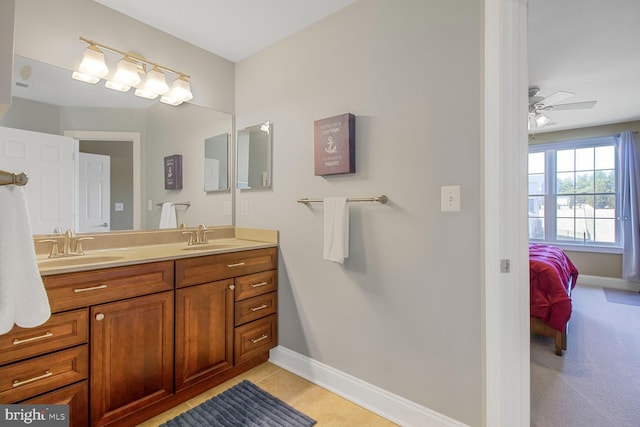 bathroom with double vanity, baseboards, and a sink