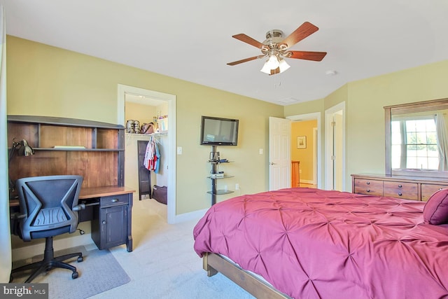 bedroom featuring light carpet, a closet, baseboards, ceiling fan, and a spacious closet