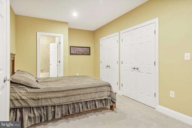 carpeted bedroom featuring recessed lighting, baseboards, multiple closets, and ensuite bathroom