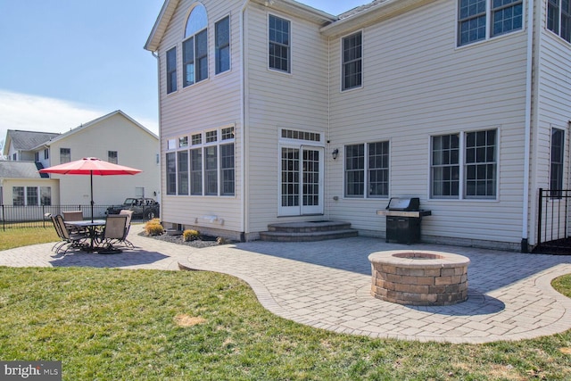 rear view of house with a patio, a fire pit, and fence