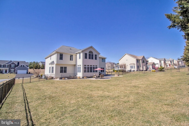 back of house featuring a patio area, a residential view, a yard, and fence