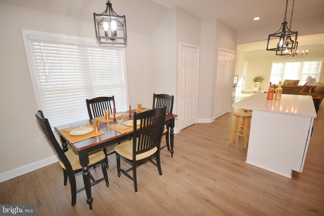 dining space featuring light wood-style floors, recessed lighting, a notable chandelier, and baseboards