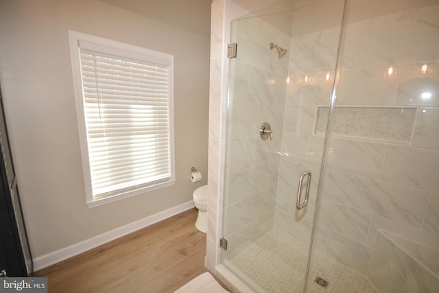 full bath with toilet, a shower stall, baseboards, and wood finished floors